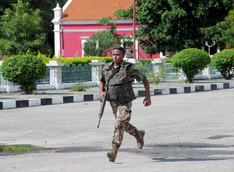 CLICK HERE - Soldier runs through downtown Dili street